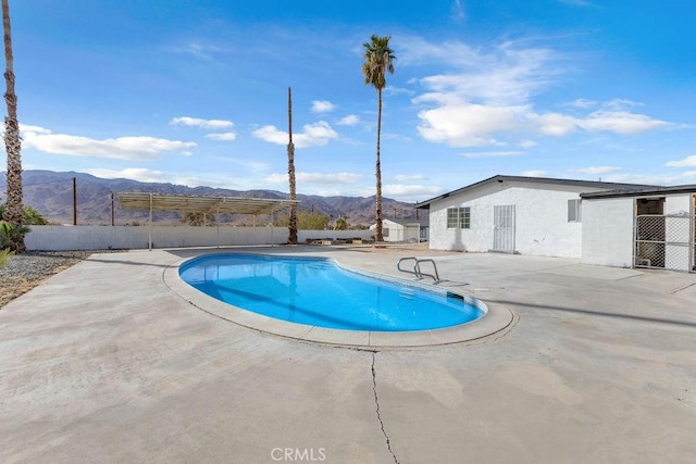 view of pool with a mountain view and a patio