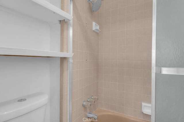 bathroom with tiled shower / bath combo and toilet