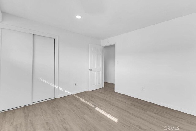 unfurnished bedroom with a closet and wood-type flooring