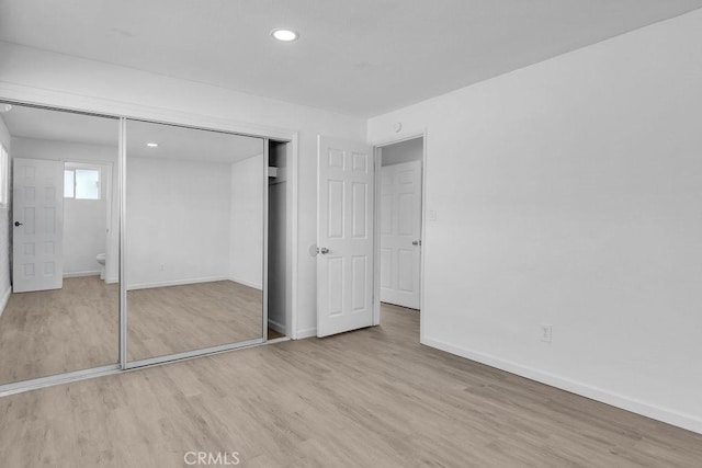 unfurnished bedroom featuring light hardwood / wood-style flooring and a closet