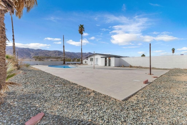 view of patio featuring a fenced in pool and a mountain view