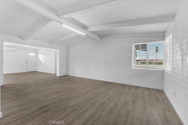 spare room with dark hardwood / wood-style flooring, a wall mounted AC, brick wall, and vaulted ceiling with beams