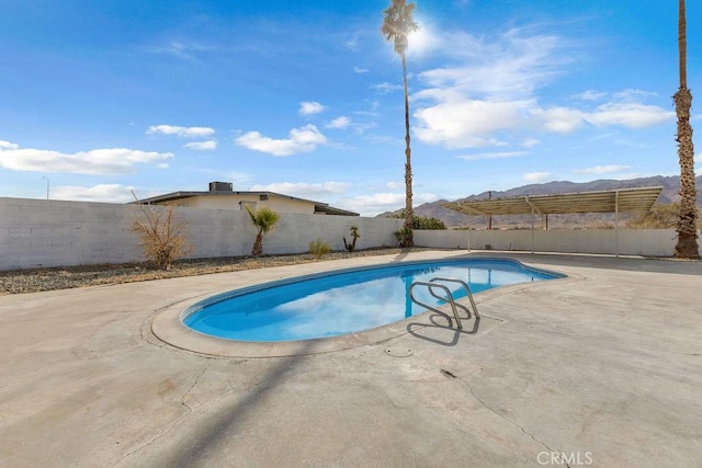 view of swimming pool featuring a mountain view and a patio