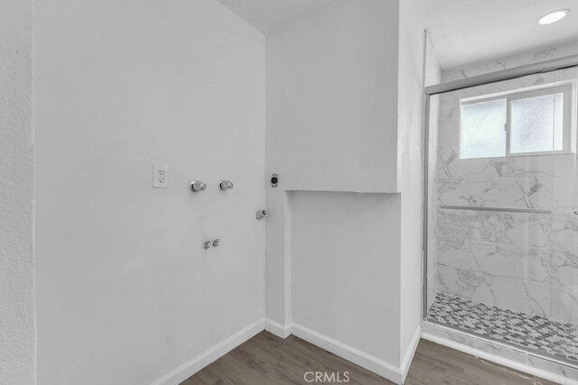 bathroom featuring a shower with door and hardwood / wood-style floors