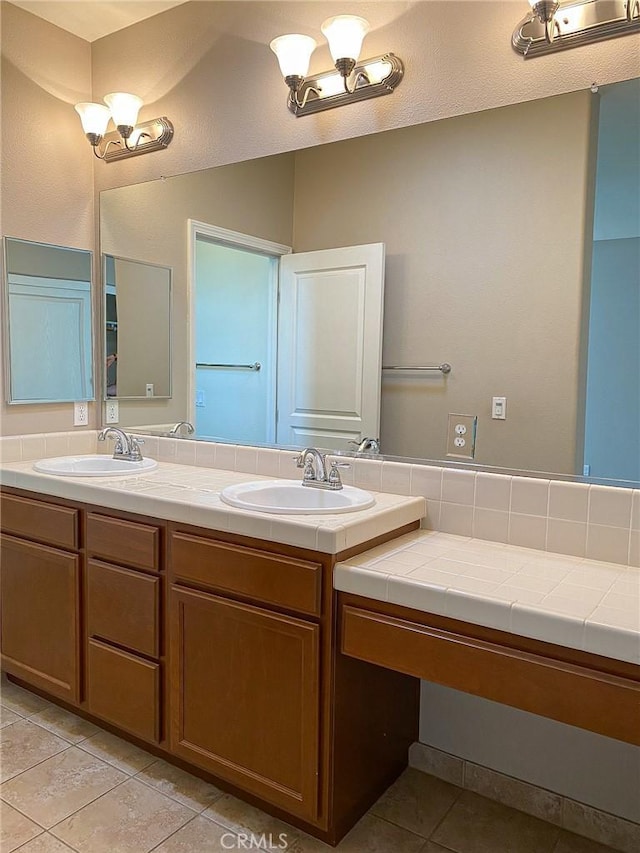 bathroom featuring an inviting chandelier, tile patterned floors, and vanity