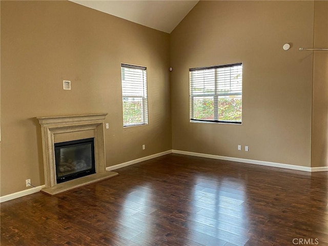 unfurnished living room featuring dark hardwood / wood-style flooring and high vaulted ceiling