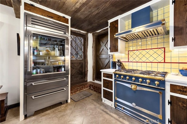 kitchen featuring backsplash, light tile patterned floors, wall chimney range hood, wooden ceiling, and gas range oven