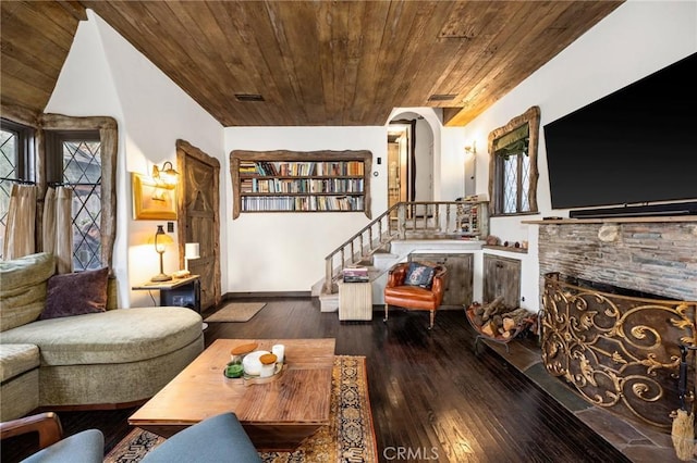 living room featuring dark hardwood / wood-style flooring, a fireplace, and wooden ceiling