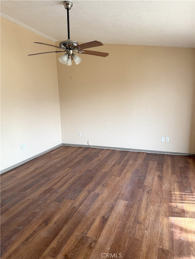 spare room featuring a ceiling fan, vaulted ceiling, dark wood finished floors, and a textured ceiling