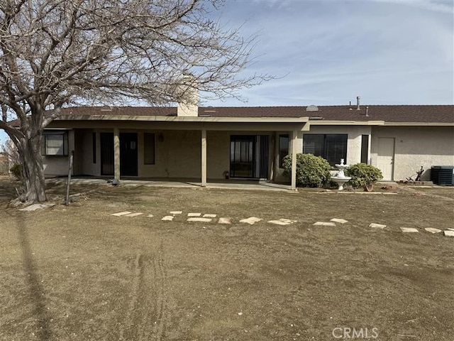 back of property with cooling unit and stucco siding