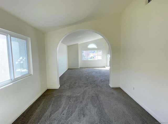 carpeted spare room featuring vaulted ceiling