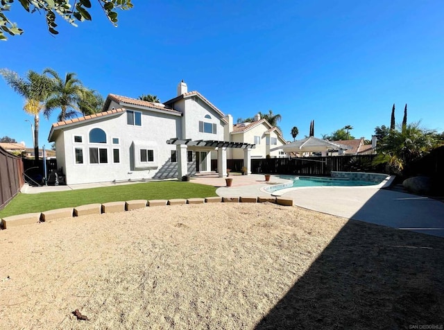 back of house featuring a fenced in pool, a patio, and a pergola