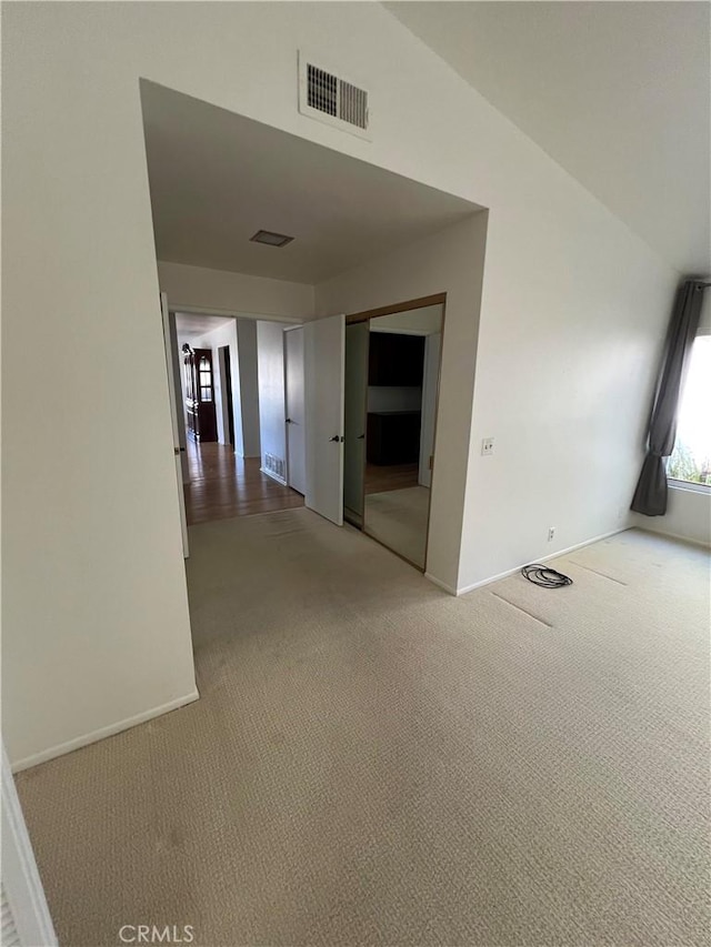 hall featuring lofted ceiling and carpet