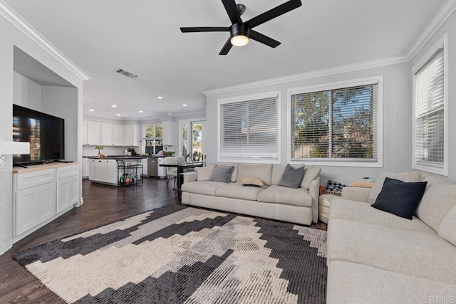 living room featuring dark hardwood / wood-style flooring, plenty of natural light, ornamental molding, and ceiling fan