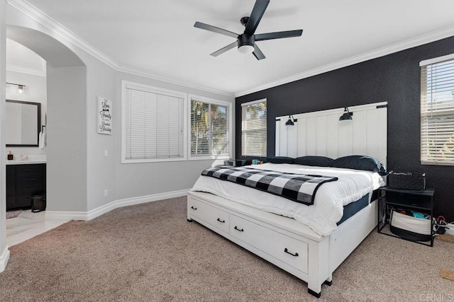 bedroom featuring crown molding, ceiling fan, light colored carpet, and ensuite bath