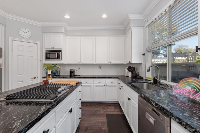 kitchen with stainless steel appliances, sink, dark stone countertops, and white cabinets