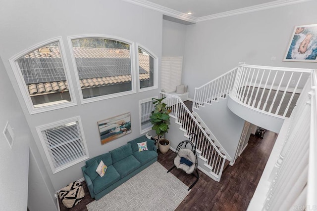 living room with crown molding, dark hardwood / wood-style floors, and a high ceiling