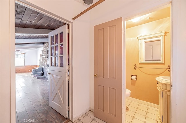 bathroom featuring beamed ceiling, tile patterned flooring, wooden ceiling, and toilet