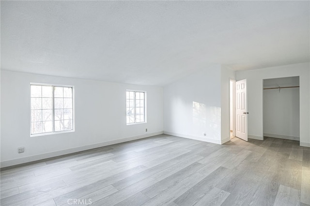 unfurnished bedroom with a textured ceiling and light hardwood / wood-style floors