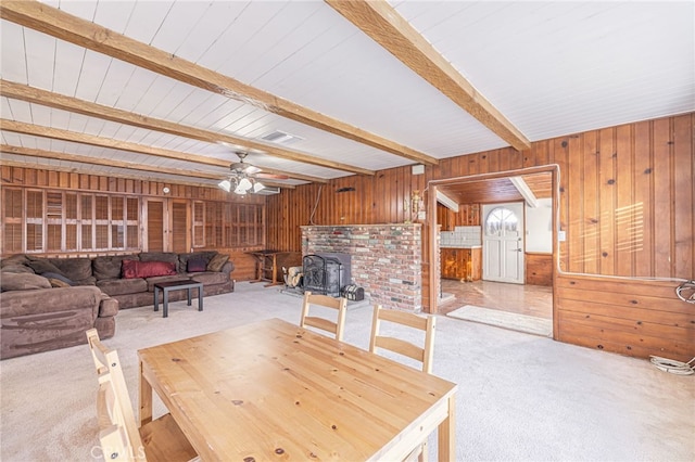 carpeted dining space with ceiling fan and beam ceiling