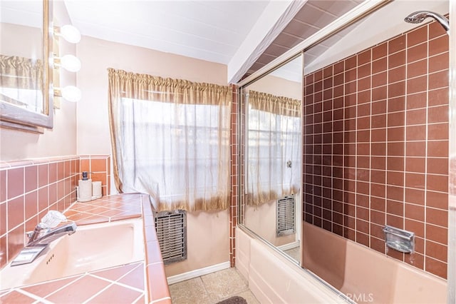 bathroom featuring sink, backsplash, and bath / shower combo with glass door