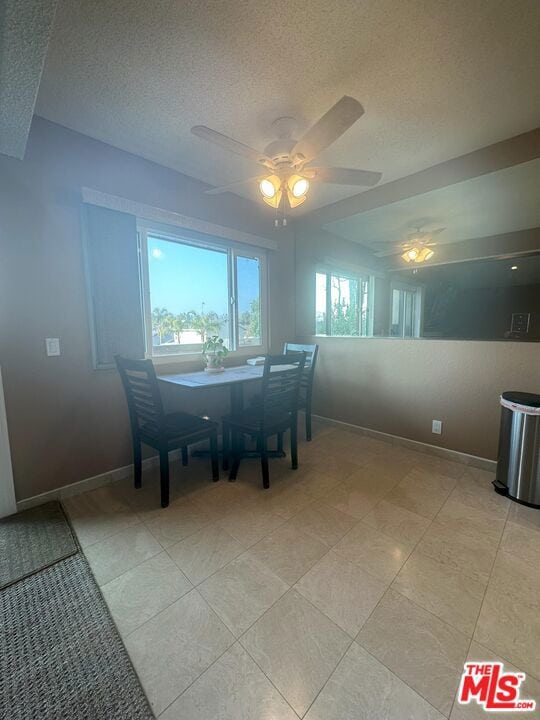 dining space featuring ceiling fan, a textured ceiling, and light tile patterned flooring