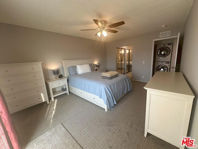 bedroom with dark carpet, stacked washer / drying machine, a textured ceiling, and ceiling fan