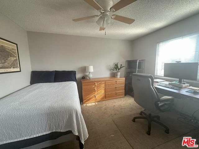 carpeted bedroom featuring ceiling fan and a textured ceiling