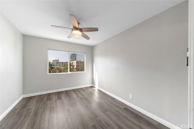 empty room with dark wood-type flooring and ceiling fan