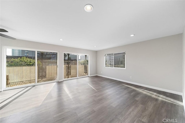 empty room with dark hardwood / wood-style floors and ceiling fan