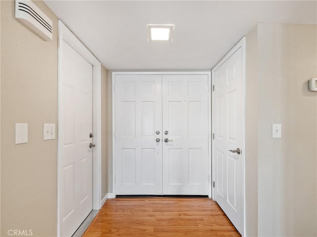 hallway featuring light hardwood / wood-style flooring and a wall unit AC