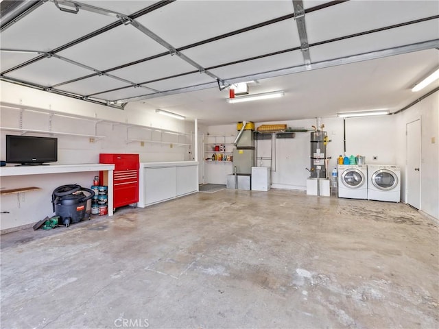 garage featuring water heater, a garage door opener, and washing machine and clothes dryer