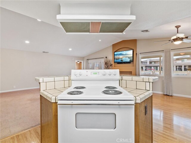 kitchen with light hardwood / wood-style flooring, electric range, tile countertops, and vaulted ceiling