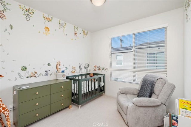 bedroom featuring light colored carpet and a nursery area