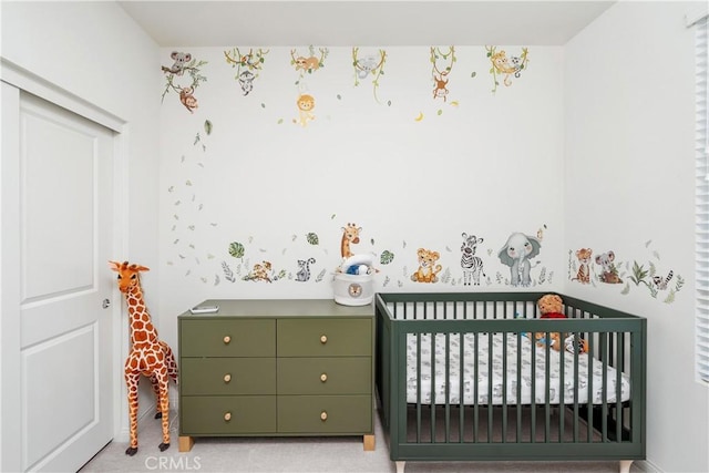 carpeted bedroom featuring a nursery area