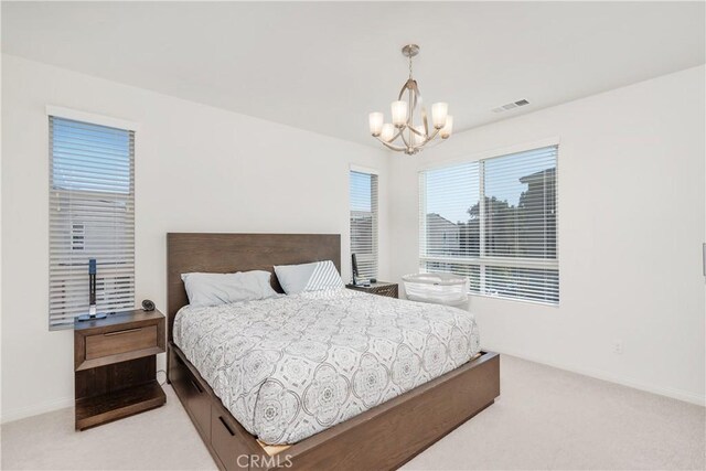 bedroom with light carpet and a notable chandelier