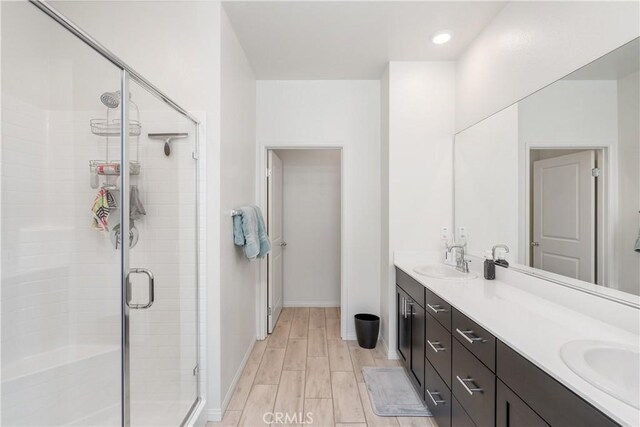 bathroom featuring vanity and a shower with door