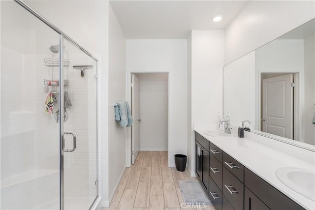 bathroom featuring vanity, a shower with door, and wood-type flooring