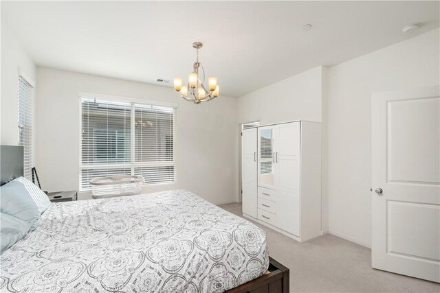 carpeted bedroom featuring an inviting chandelier