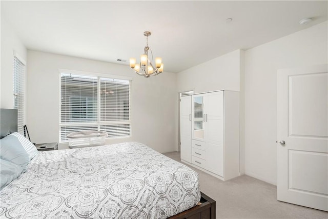 bedroom with light colored carpet and an inviting chandelier