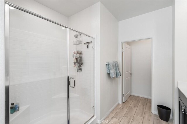 bathroom with a shower with door and vanity