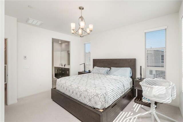 carpeted bedroom with an inviting chandelier, ensuite bath, sink, and multiple windows