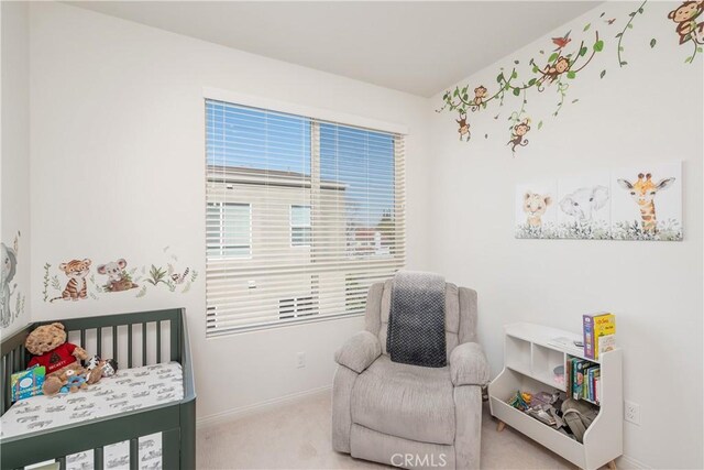 bedroom featuring a nursery area and light colored carpet