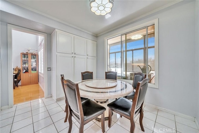 dining space featuring light tile patterned floors and crown molding