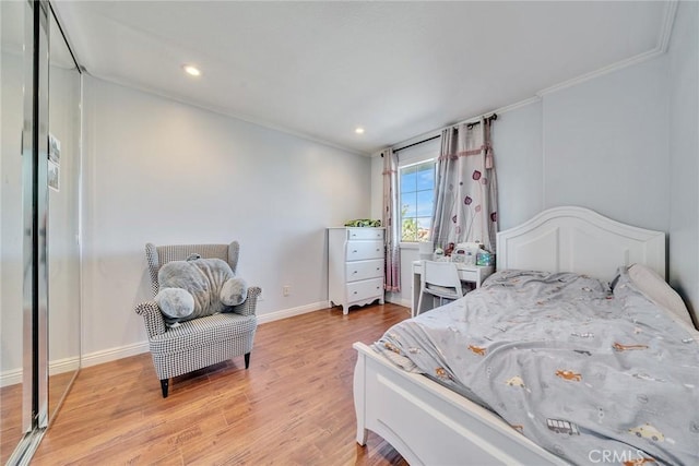 bedroom with ornamental molding and light hardwood / wood-style flooring