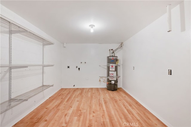 basement with secured water heater and hardwood / wood-style flooring