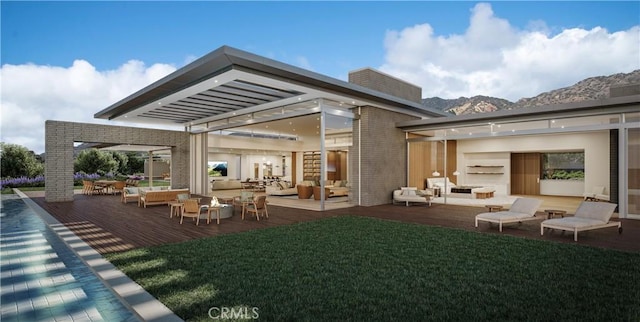 rear view of property with a pergola, a deck with mountain view, an outdoor hangout area, and a lawn