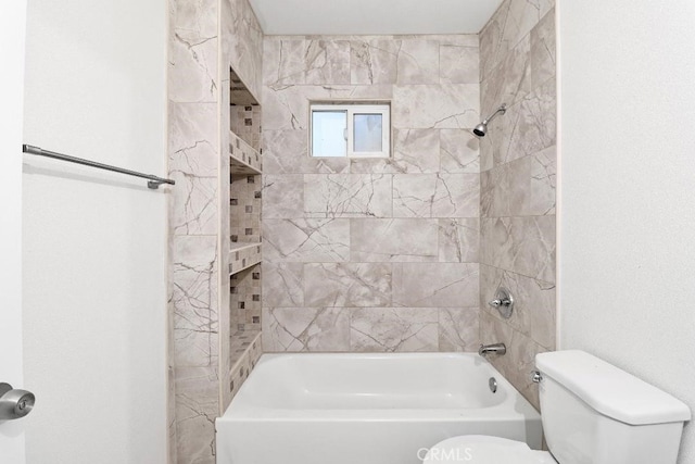 bathroom with tiled shower / bath combo and toilet