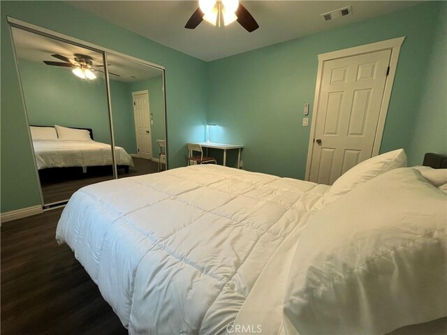 bedroom featuring dark wood-type flooring, ceiling fan, and a closet