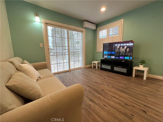 living room with wood-type flooring and an AC wall unit